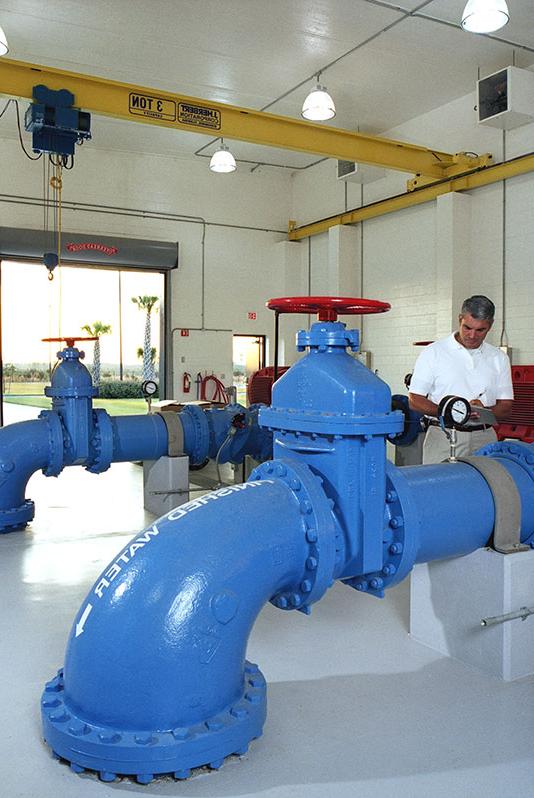 Interior photo from inside the facility. Large blue pipes and valves.